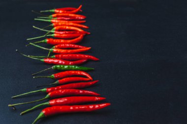 Kırmızı biber siyah arka planda yatar. Geleneksel Asya yemekleri. Tayland baharatları.