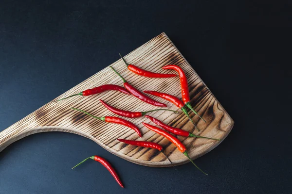 Chiles Rojos Picantes Una Tabla Cortar Fondo Negro — Foto de Stock