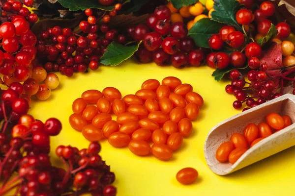 Koenzim Q 10 hapları kalp şeklinde dizilmiştir. Vitamin ve böğürtlenli sonbahar kompozisyonu. Pankart için resimler, poster.