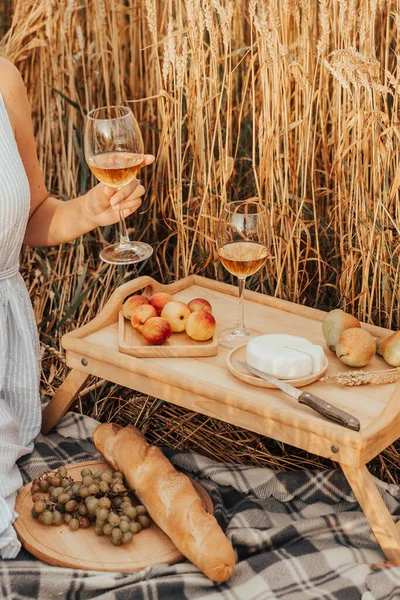 The girl drinks aperol on picnic. Summer outdoor recreation.