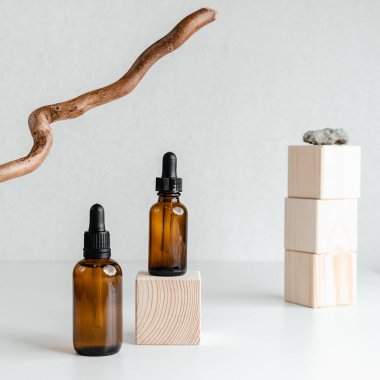 Beyaz arka planda yüz serumu olan bir şişe. Unisex kozmetik. Mesaj için yer. Olgun cilt için esans ahşap ayakta durur. Spa doğal organik ürünler. Erkekler ve kadınlar için anti-yaş kozmetikleri.. 