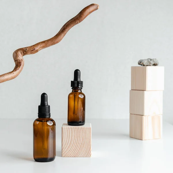 Beyaz arka planda yüz serumu olan bir şişe. Unisex kozmetik. Mesaj için yer. Olgun cilt için esans ahşap ayakta durur. Spa doğal organik ürünler. Erkekler ve kadınlar için anti-yaş kozmetikleri.. 