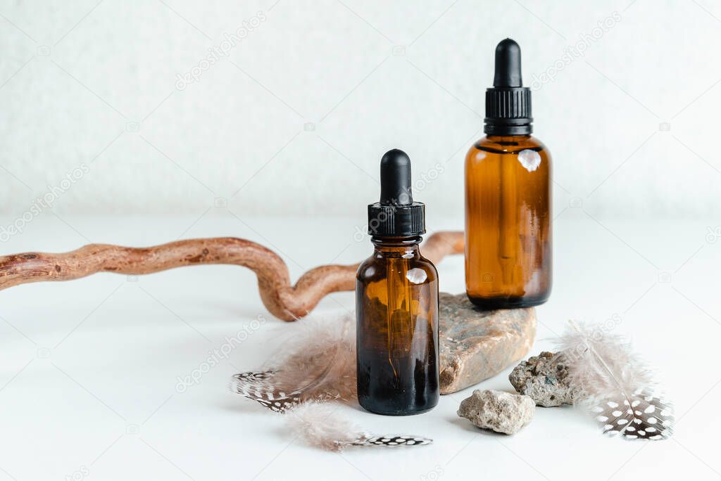 Bottle with face serum on white background. Unisex cosmetics. Place for  text. Essence for mature skin stands on  wooden stand. Spa natural organic products.Anti-age cosmetics for men and women.