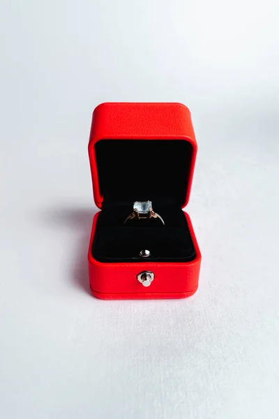 An engagement ring in  red gift box on white background.  Marry me. Luxury accessory. Place for text
