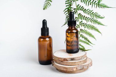 Broşürlü aromaterapi için bir şişe spa yağı. Beyaz arka planda deri sağlığı için bir şişe öz ve surum. Siyah camlı doğal bitkisel cilt bakım ürünleri. Model reklamcılık. 