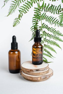 Broşürlü aromaterapi için bir şişe spa yağı. Beyaz arka planda deri sağlığı için bir şişe öz ve surum. Siyah camlı doğal bitkisel cilt bakım ürünleri. Model reklamcılık. 