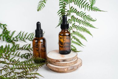 Broşürlü aromaterapi için bir şişe spa yağı. Beyaz arka planda deri sağlığı için bir şişe öz ve surum. Siyah camlı doğal bitkisel cilt bakım ürünleri. Model reklamcılık. 