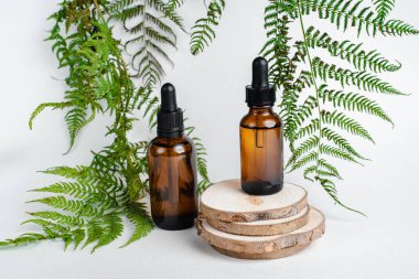 Broşürlü aromaterapi için bir şişe spa yağı. Beyaz arka planda deri sağlığı için bir şişe öz ve surum. Siyah camlı doğal bitkisel cilt bakım ürünleri. Model reklamcılık. 