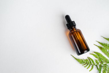 Broşürlü aromaterapi için bir şişe spa yağı. Beyaz arka planda deri sağlığı için bir şişe öz ve surum. Siyah camlı doğal bitkisel cilt bakım ürünleri. Model reklamcılık. 