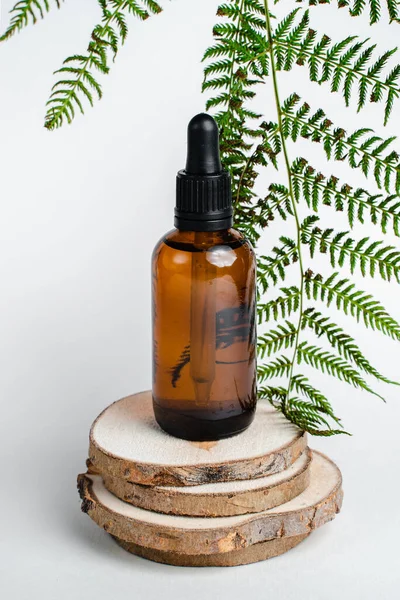 Broşürlü aromaterapi için bir şişe spa yağı. Beyaz arka planda deri sağlığı için bir şişe öz ve surum. Siyah camlı doğal bitkisel cilt bakım ürünleri. Model reklamcılık. 