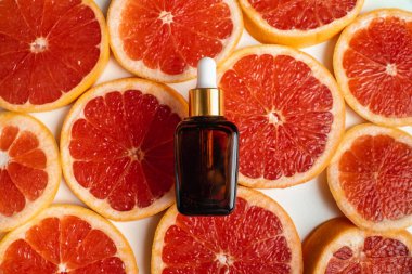 Greyfurt özlü bir şişe. Moda tarzında organik doğal kozmetik ürünü. Deri gerdirme için anti-yaş kozmetikleri. Koyu cam şişede serum. Metin için yer