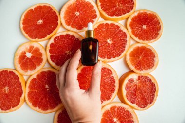 Greyfurt özlü bir şişe. Moda tarzında organik doğal kozmetik ürünü. Deri gerdirme için anti-yaş kozmetikleri. Koyu cam şişede serum. Metin için yer