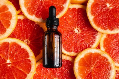 Greyfurt özlü bir şişe. Moda tarzında organik doğal kozmetik ürünü. Deri gerdirme için anti-yaş kozmetikleri. Serum siyah cam şişede. Metin için yer