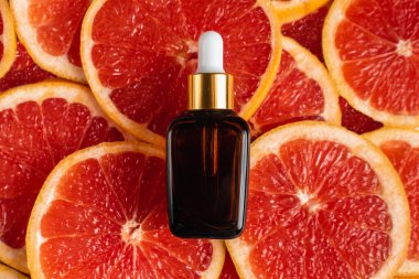 Greyfurt özlü bir şişe. Moda tarzında organik doğal kozmetik ürünü. Deri gerdirme için anti-yaş kozmetikleri. Serum siyah cam şişede. Metin için yer