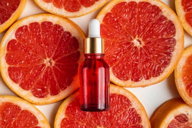 Greyfurt özlü bir şişe. Moda tarzında organik doğal kozmetik ürünü. Deri gerdirme için anti-yaş kozmetikleri. Kırmızı cam şişede serum. Metin için yer