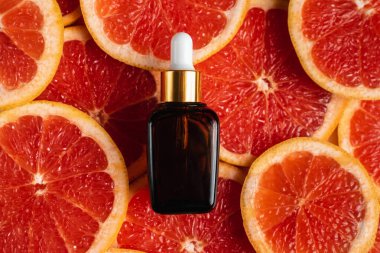 Greyfurt özlü bir şişe. Moda tarzında organik doğal kozmetik ürünü. Deri gerdirme için anti-yaş kozmetikleri. Serum siyah cam şişede. Metin için yer