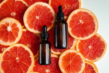 Greyfurt özlü bir şişe. Moda tarzında organik doğal kozmetik ürünü. Deri gerdirme için anti-yaş kozmetikleri. Serum siyah cam şişede. Metin için yer