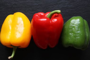 Üç dolmalık biberin fotoğrafı yemek arkaplanı için sıraya dizildi