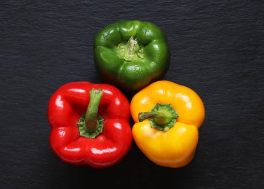 Yemek arkaplanındaki üç dolmalık biberin fotoğrafı.