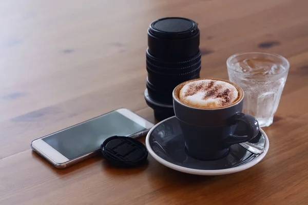 Cappuccino Kaffee Und Smartphone Mit Linse Auf Dem Tisch — Stockfoto