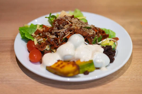 Salat in weißem Teller auf Tisch — Stockfoto