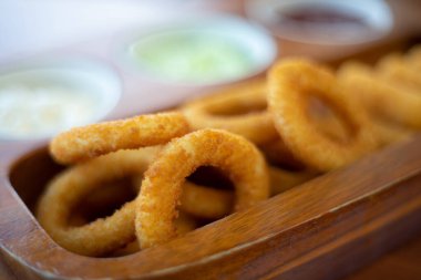 Kızarmış peynir, ahşap tepside sosisli soğan..