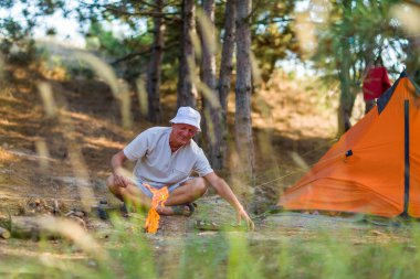 Adam kamp ateşinde yemek pişiriyor..