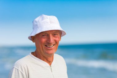 Adam denizin kenarında durur ve gülümser.. 