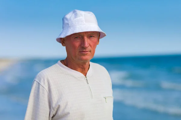 Deniz kenarında duran bir adamın portresi.