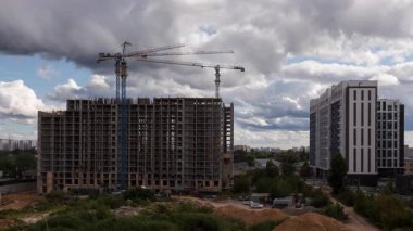 Şehir merkezinde bir yerleşim tesisi inşa eden vinçlerin zamanlaması, inşaat ilerlemesini, emlak piyasası büyümesini ve emlak gelişimini ön plana çıkaran statik geniş açı.