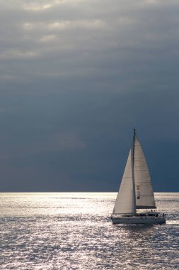 Karanlık gökyüzü ve deniz içinde tek yat