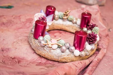 Noel dekorasyon yuvarlak çelenk, parlak aksesuarlar, mumlar ve koniler, pembe, gümüş, pembe kağıt ambalaj