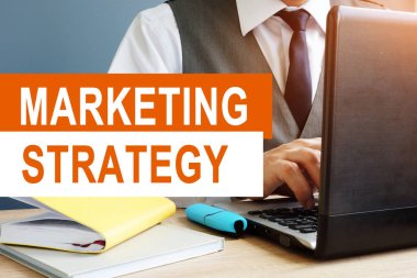 Pazarlama stratejisi kavramı. Bir dizüstü bilgisayarda çalışma pazarlamacı.