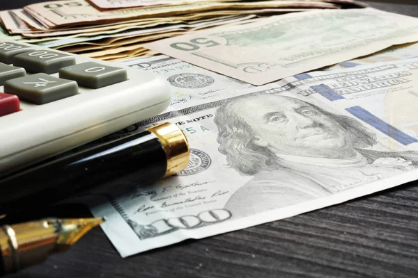 財政またはローンの概念 ドル紙幣と机の上の電卓 — ストック写真