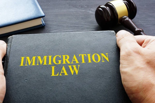 Hands Holding Immigration Law Book — Stock Photo, Image