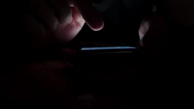 Sosyal medya smartphone içinde kaydırma eller Close-up. Gece vakti.