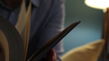 Bir kitap ve sayfaları çevirme eller.