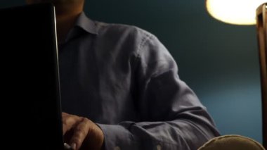 Adam bir laptop onun evinde akşam yazarak.