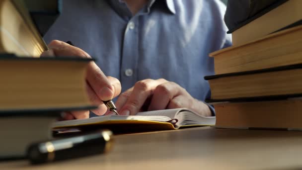 Jonge Man Schrijven Bibliotheek Stapels Boeken Een Tafel — Stockvideo