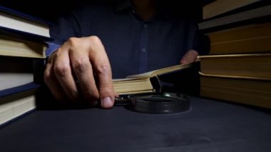 Kitap okumak için Büyüteç kullanan adam. Araştırma ve geliştirme.