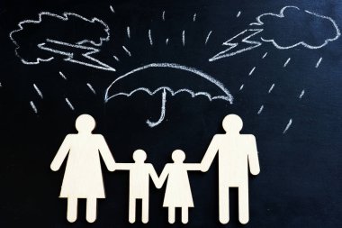 Hayat sigortası. Çizilmiş yağmur ve şemsiyesi altında aile rakamlar.