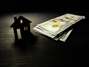 Model ev ve para içinde belgili tanımlık karanlık. İpotek veya kira kavramı dolara.