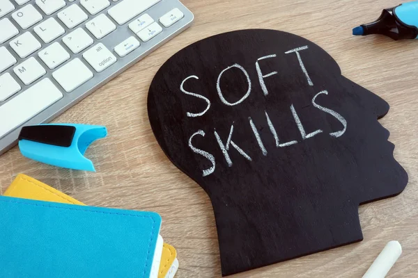 Soft skills written on a blackboard with the shape of a head.