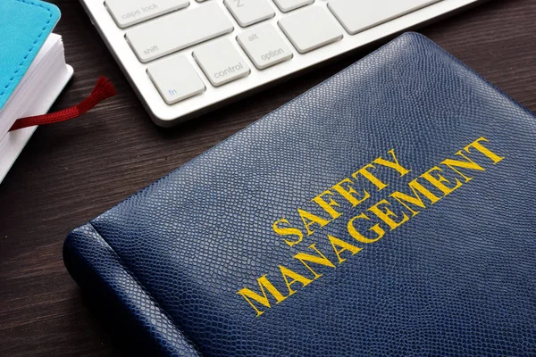 Safety management book and keyboard on a desk.