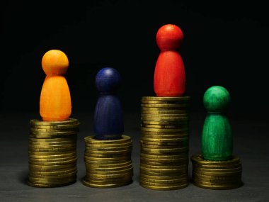 Servet yönetimi ve para tasarrufu. Ahşap figürler ve madeni paralar.