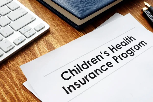 儿童健康保险计划在办公桌上的芯片文档 — 图库照片