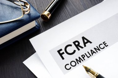 Ahşap bir masa üzerine FCRA uygunluk formu.