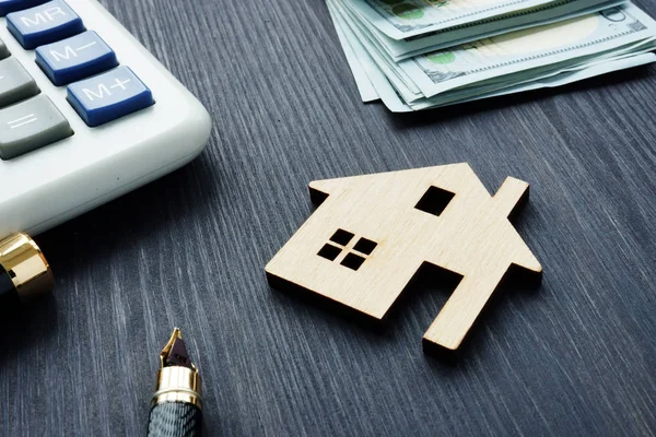 Concepto de valor de casa. Modelo de casa en una madera oscura con calculadora y dinero . —  Fotos de Stock