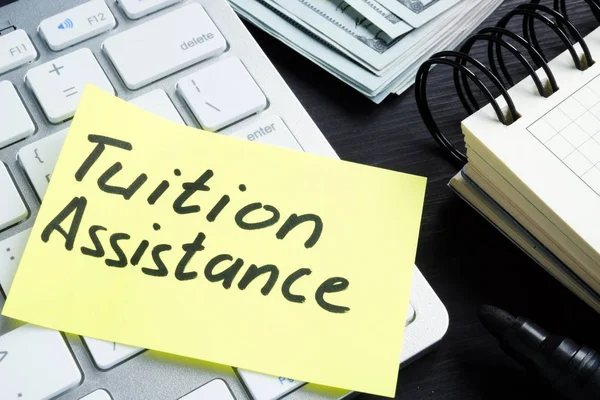 Tuition assistance handwritten on a piece of paper and calculator. — Stock Photo, Image