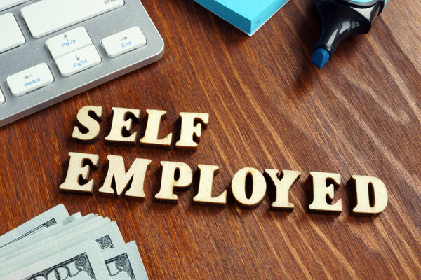 Word self employed on an office desk.